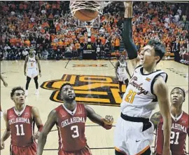  ?? Sue Ogrocki Associated Press ?? OKLAHOMA STATE’S Lindy Waters III dunks in front of Oklahoma’s Trae Young (11), Khadeem Lattin (3) and Kristian Doolittle in the second half.