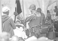  ??  ?? File photo shows a Royal Canadian Mounted Police officer talking to migrants after they crossed the Canada/US border illegally near Hemmingfor­d, Quebec. — AFP photo