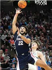  ?? RICK BOWMER / AP ?? Gonzaga forward Anton Watson shoots as Kansas guard Johnny Furphy looks on during Saturday’s second-round game in Salt Lake City.