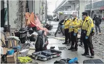  ?? CHRIS YOUNG THE CANADIAN PRESS ?? Police officers speak to a homeless person as city workers clear an encampment on Toronto's Bay Street.