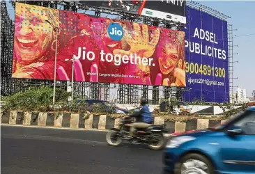  ??  ?? Major player: Traffic travels past a billboard for Reliance Jio Infocomm Ltd in the Bandra area of Mumbai. Jio, which had 152 million subscriber­s at the end of November, has elbowed aside rivals to become India’s No. 4 wireless carrier. — Bloomberg