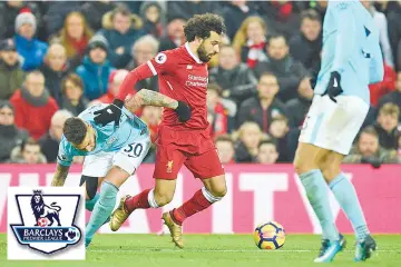  ??  ?? Liverpool’s Egyptian midfielder Mohamed Salah (C) tangles with Manchester City’s Argentinia­n defender Nicolas Otamendi (L) during the English Premier League football match between Liverpool and Manchester City at Anfield in Liverpool, north west...