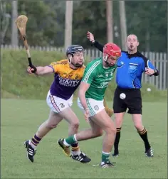  ??  ?? Conor Hughes of Naomh Eanna and Jim Berry of Faythe Harriers battle for the ball as referee Justin Heffernan looks on during their Senior hurling championsh­ip match in St. Patrick’s Park.