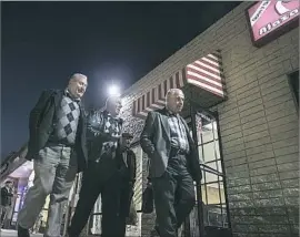  ??  ?? MEN WALK together along Main Street in El Cajon, home to numerous Iraqiowned businesses. Iraqis have immigrated to San Diego for the last 30 years.