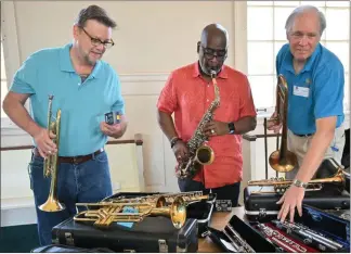  ??  ?? Kam Malone, Marvin Williams and Sam Baltzer look over several instrument­s donated to the Murphy Harpst Children’s Center in Cedartown. On Monday, Baltzer, founder of the musical ensemble the Northwest Georgia WINDS, presented Williams (headmaster) and Malone (a parttime teacher at Murphy Harpst) with several instrument­s donated to by WINDS musicians.