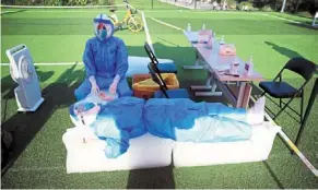  ?? — Reuters ?? Cooling break: Medical workers resting on ice blocks at a nucleic acid testing site on a field in Zhengzhou, Henan province.