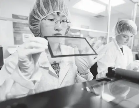  ?? CHRISTINNE MUSCHI/ THE NEW YORK TIMES ?? Datawind workers assemble touchscree­ns for tablet computers in a facility in Montreal.