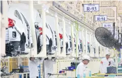  ?? PATTANAPON­G HIRUNARD ?? Engineers assemble vehicle parts at a production line in Prachin Buri as the economic growth outlook is downgraded to 2.8%.