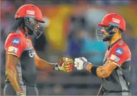  ?? AFP ?? Royal Challenger­s Bangalore’s captain Virat Kohli (right) pumps fists with teammate Chris Gayle during an Indian Premier League tie against Gujarat Lions in Rajkot on Tuesday.