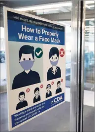  ?? Nam Y. Huh / Associated Press file photo ?? A sign stating face coverings are required is displayed at O'Hare airport in Chicago.