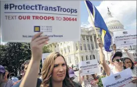  ?? JUSTIN SULLIVAN / GETTY IMAGES ?? Gay rights supporters hold signs during a press conference at the U.S. Capitol condemning the new ban on transgende­r service members Wednesday in Washington, D.C. U.S. Rep. Joe Kennedy, members of the House leadership and the LGBT Equality Caucus...