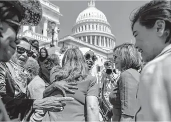  ?? Photos by Andrew Harnik/Associated Press ?? Rep. Ilhan Omar, center, hugs Houston Rep. Lizzie Fletcher at a Democratic event ahead of a House vote on bills that would restore abortion access and prevent states from barring travel.