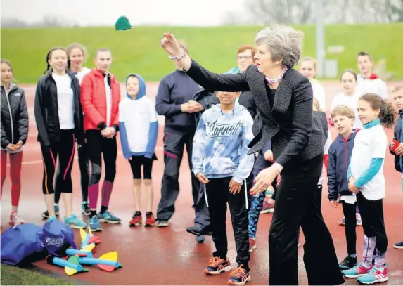  ??  ?? > Theresa May joined young athletes from the Alexander Stadium athletics club during her visit to announce a £70 million investment for the 2022 Games