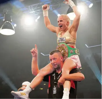  ?? Fotos: Siegfried Kerpf ?? So sieht eine Weltmeiste­rin aus. Trainer Alexander Haan trug seine Boxerin Tina Rupprecht nach deren Kampf gerne durch den Ring.