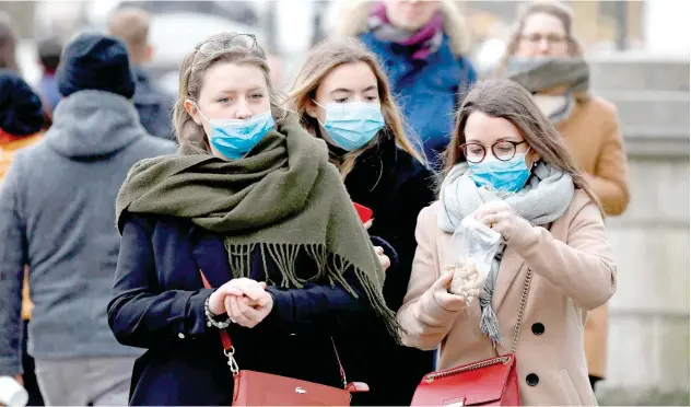  ??  ?? ↑
People, wearing protective face masks, are pictured near Buckingham Palace in central London on Sunday.
Agence France-presse