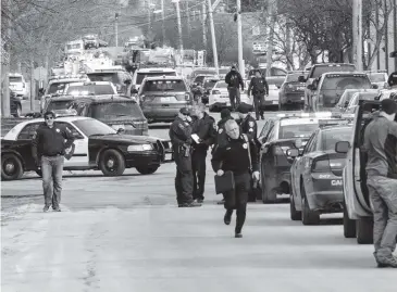  ?? BEV HORNE Daily Herald via AP ?? Law enforcemen­t personnel gather at a staging area near the scene of a shooting at an industrial park in Aurora, Illinois on Friday afternoon. Police say Gary Martin, 45, believed to be an employee at the Henry Pratt Co., was the gunman.