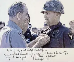  ?? COURTESY OF THE FAMILY ?? President Lyndon Johnson referred to Ralph Puckett Jr. as “a proud son of Georgia” in a handwritte­n message on a photograph of the two men during Puckett’s days of active duty service.