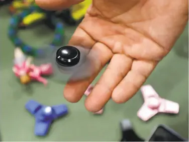  ?? Carlos Osorio / Associated Press ?? A consumer group says popular fidget spinners contain small parts that can be a choking hazard.