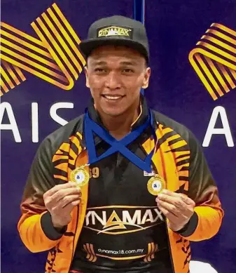  ??  ?? Bad news: Hafifi Mansor showing off the gold medal he won in the men’s below 69kg with a combined total of 307kg in the Australian Open in Melbourne in March.