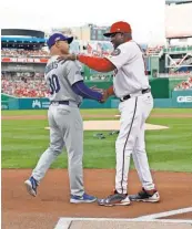  ?? ALEX BRANDON, AP ?? The Dodgers’ Dave Roberts, left, and the Nationals’ Dusty Baker, shaking hands before an NL Division Series game last year, are MLB’s only two African- American managers.