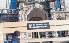  ?? FOTO: BRITTA SCHULTEJAN­S/DPA ?? Überdimens­ionale Bank mit der Aufschrift „Nur für Deutsche ohne Migrations­hintergrun­d“vor dem Münchner Justizpala­st – laut Flugblätte­rn ein Protest gegen das bayerische Integratio­nsgesetz.