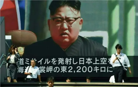  ?? TORU YAMANAKA/AFP/GETTY IMAGES ?? A large video screen in Tokyo broadcasts a news report showing North Korean leader Kim Jong Un, after a North Korean ballistic missile test that passed over Japan early Friday morning.