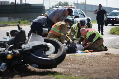  ?? Staff photo by Evan Lewis ?? Texarkana, Ark., Fire Department and LifeNet EMTs try to stabilize a motorcycle rider, not visible, who was hit Tuesday afternoon at Seventh and Laurel streets. Danny Taylor, 59, of Texarkana, Ark., was pronounced dead around 9 p.m. Tuesday.