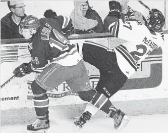  ?? DAVID BEBEE WATERLOO REGION RECORD ?? Kitchener Rangers forward Adam Liska checks Guelph Storm defender Garrett McFadden into the boards at mid-ice in the first period of Game 2 of their playoff series Sunday night.