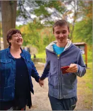  ?? ?? Kelley Goad walks with her 24-year-old son, Jacob, who was diagnosed with autism when he was 18 months old. Jacob lives in a residentia­l community near his parents.