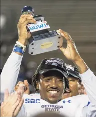  ?? Vasha Hunt / Associated Press ?? Georgia State quarterbac­k Darren Grainger holds the MVP trophy after the team’s Camellia Bowl NCAA game against Ball State on Saturday in Montgomery, Ala. Georgia State won 51-20.