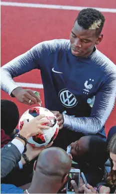  ?? Reuters ?? France’s Paul Pogba signs autographs for fans during training. Pogba is crediting Deschamps, who uses him on the pitch in a less restricted role than Mourinho, for his positive influence.