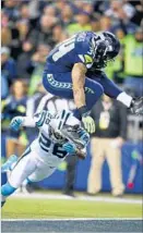  ?? Otto Greule Jr. Getty Images ?? SEATTLE’S THOMAS RAWLS, top, tries to evade Carolina’s Daryl Worley.