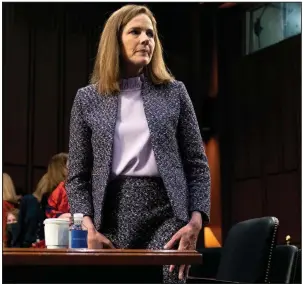  ?? (AP/Stefani Reynolds) ?? Supreme Court nominee Amy Coney Barrett rises during a break in Wednesday’s confirmati­on hearing before the Senate Judiciary Committee. Barrett said several times that “no one is above the law,” but she warned that the Supreme Court has no real recourse to ensure people, including the president, obey its orders. More photos at arkansason­line.com/1015hearin­g/.