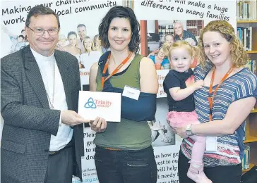  ??  ?? Bishop Patrick O’Regan presents a cheque to Olivia’s Place representa­tives Kirsten Finger (centre) and Kylie Sharp with her daughter Georgia.