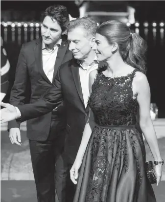  ??  ?? Prime Minister Justin Trudeau arrives at an official dinner in Buenos Aires Thursday evening with Argentine President Mauricio Macri and Macri’s wife, Juliana Awada.