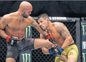  ?? CP PHOTO ?? Rafael Dos Anjos battles against Robbie Lawler, left, in main event action at the UFC Fight Night — Lawler vs Dos Anjos event in Winnipeg on Saturday.