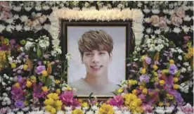  ??  ?? The portrait of Kim Jong-Hyun, a 27-year-old lead singer of the massively popular K-pop boyband SHINee, is seen on a mourning altar at a hospital in Seoul yesterday. — AFP