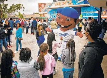  ?? Photograph­s by Jason Armond Los Angeles Times ?? A DODGERS MASCOT greets children at Orville Wright STEAM Magnet Middle School in Westcheste­r, where about 1,000 volunteers showed up to give the campus a makeover on Martin Luther King Jr. Day.