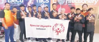  ?? ?? Dr Khairuddin (fifth right), Badrol (seventh left) and their charges pose for a group photo, taken during the homecoming ceremony at the KIA. Also in the shot are Sarawak Special Olympics Kuching Chapter deputy president Lau Tine Lee (second left) and Sarawak Special Olympics sports director Myron Khoo (second right).