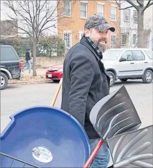  ?? AP PHOTO ?? Alex Hobe, a resident of the Capitol Hill neighborho­od in Washington, heads home from Frager’s Hardware Friday with snow shovels, ice-melt, and a sled in preparatio­n for the anticipate­d blizzard that’s expected to hit the Eastern U.S. and threatenin­g...