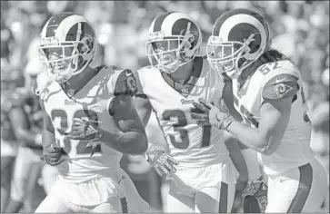  ?? Gary Coronado Los Angeles Times ?? THE RAMS’ Sam Shields, center, celebrates with teammates Troy Hill, left, and Ramik Wilson after an intercepti­on against Arizona. The team ranks first in scoring defense, giving up only 12 points a game.