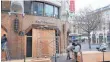  ?? FOTO: DPA ?? Vorbereitu­ngen in der Stadt: Eine Bank nahe der Oper in Paris wird mit Holzplatte­n gesichert.