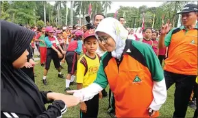  ??  ?? BIAR TETAP SEHAT: Budi Utomo, pencipta gerakan senam UKS seri 2, memandu senam masal di AlunAlun Sidoarjo yang diikuti Bupati Saiful Ilah kemarin. Foto kanan, dr Linda Siti, anggota tim juri lomba UKS tingkat nasional, memeriksa kuku Melisa Juliansti,...