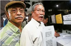  ??  ?? Not happy: Activists holding up documents after filing a petition to hold Marcos’ heirs and officials in contempt for carrying out the burial. — AP