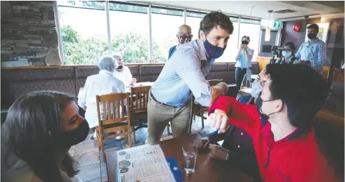  ?? DARRYL DYCK / THE CANADIAN PRESS ?? Prime Minister Justin Trudeau greets diners in Coquitlam, B.C. Electorate­s do not tend to favour elections called on the basis of opportunis­m when the incumbent party is under no threat of parliament­ary defeat, Conrad Black writes.