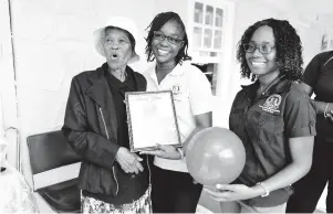  ??  ?? Sybil Watt (left) collects a plaque from Ardine Bartley Lyons (centre), team leader for Manchester, and Kemolyn Frost, foster care officer, Manchester.