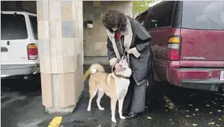  ?? Ash Adams For The Times ?? AVONNA MURFITT takes her late son’s dog for a walk outside her Anchorage office. Adrian called her Sunday afternoon to share his excitement and ask what she wanted for her birthday.