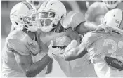  ?? TAIMY ALVAREZ/STAFF PHOTOGRAPH­ER ?? Maurice Smith, center, has a decent chance to make the team, but needs to excel on special teams.