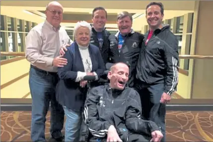  ?? COURTESY LYONS FAMILY ?? Dr. Bryan Lyons (middle, back row) prior to the 2014 Boston Marathon. Standing behind Rick Hoyt (in wheelchair) were, from left, Lyons' parents, John and Pat, Lyons, Dick Hoyt, and Lyons' brother, Mark Lyons. Dr. Lyons pushed Rick in the Boston Marathon when his father was unable to.