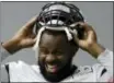  ?? MATT ROURKE — THE ASSOCIATED PRESS ?? Eagles defensive tackle Fletcher Cox pulls on his helmet during practice Thursday.